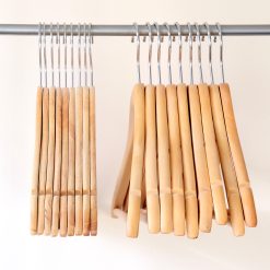 Slimline wooden hangers on rail next to standard wooden hangers